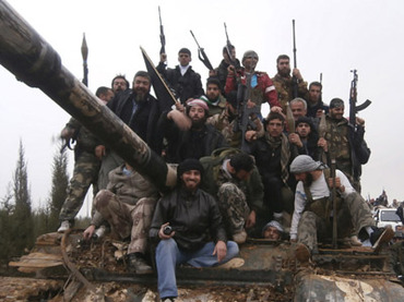 Free Syrian Army fighters pose on a tank, which they say was captured from the Syrian army loyal to President Bashar al-Assad, after clashes in Qasseer