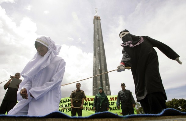 Murni Amris, an Acehnese woman, is caned as part of her sentence in the courtyard of a mosque in Aceh Besar district