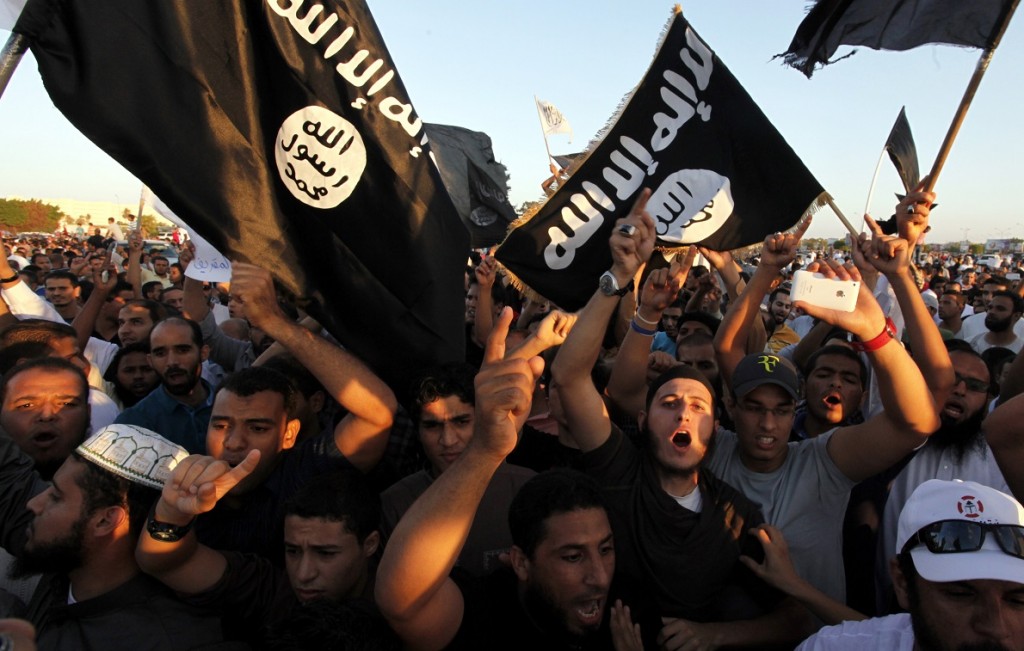 FILE - In this Sept. 21, 2012 file photo, Libyan followers of Ansar al-Shariah Brigades and other Islamic militias, hold a demonstration against a film and a cartoon denigrating the Prophet Muhammad in Benghazi, Libya.  On Friday, Oct. 31, 2014, bearded militants gathered at a stage strung with colorful lights in Darna, a Mediterranean coastal city long notorious as Libya's center for jihadi radicals. With a roaring chant, they pledged their allegiance to the leader of the Islamic State group. Many of Darna's militants joined, though some didn't. Part of Ansar al-Shariah, one of the country's most powerful Islamic factions, joined while another part rejected it. (AP Photo/Mohammad Hannon, File)